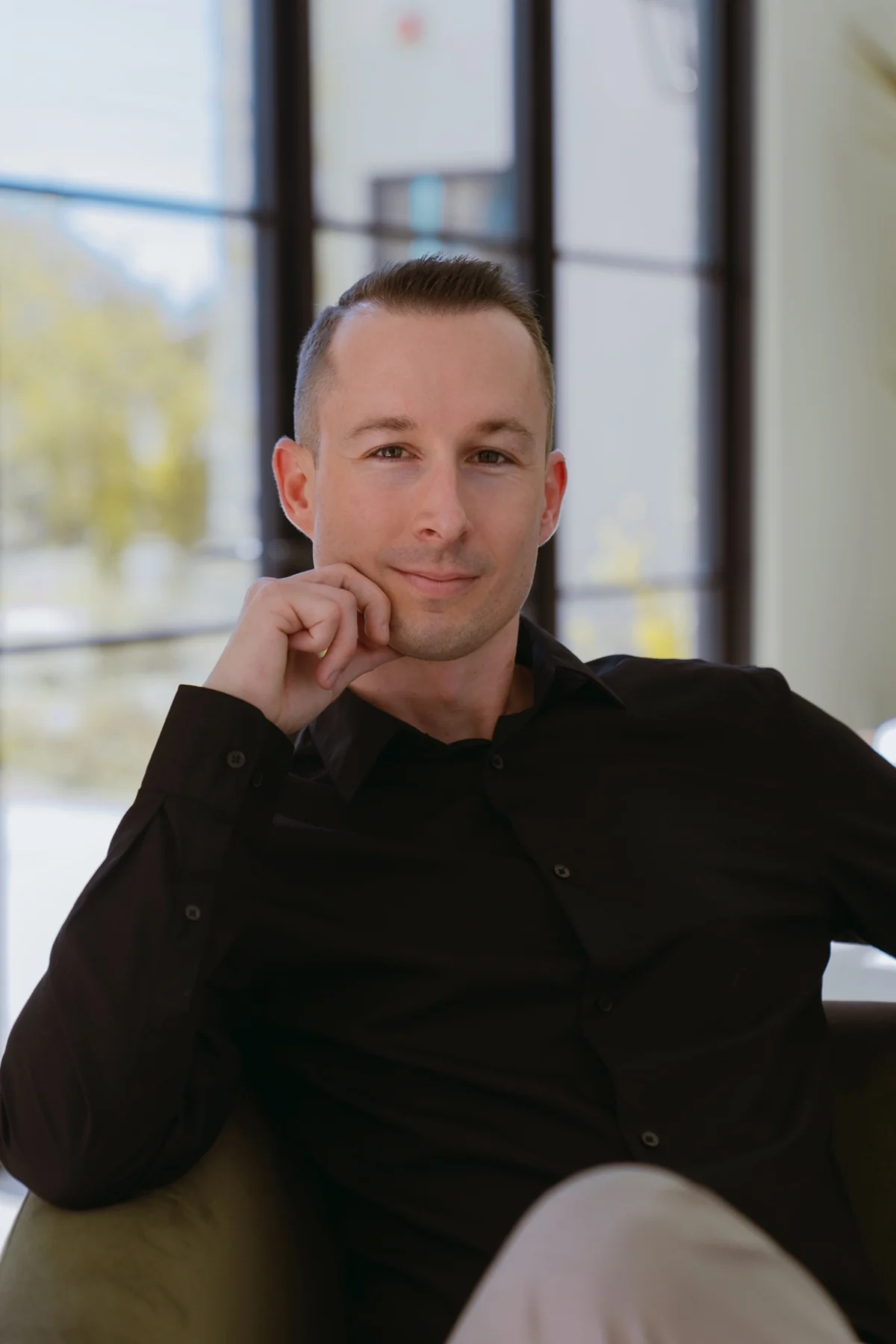 Portrait of Justin Taylor seated by a window